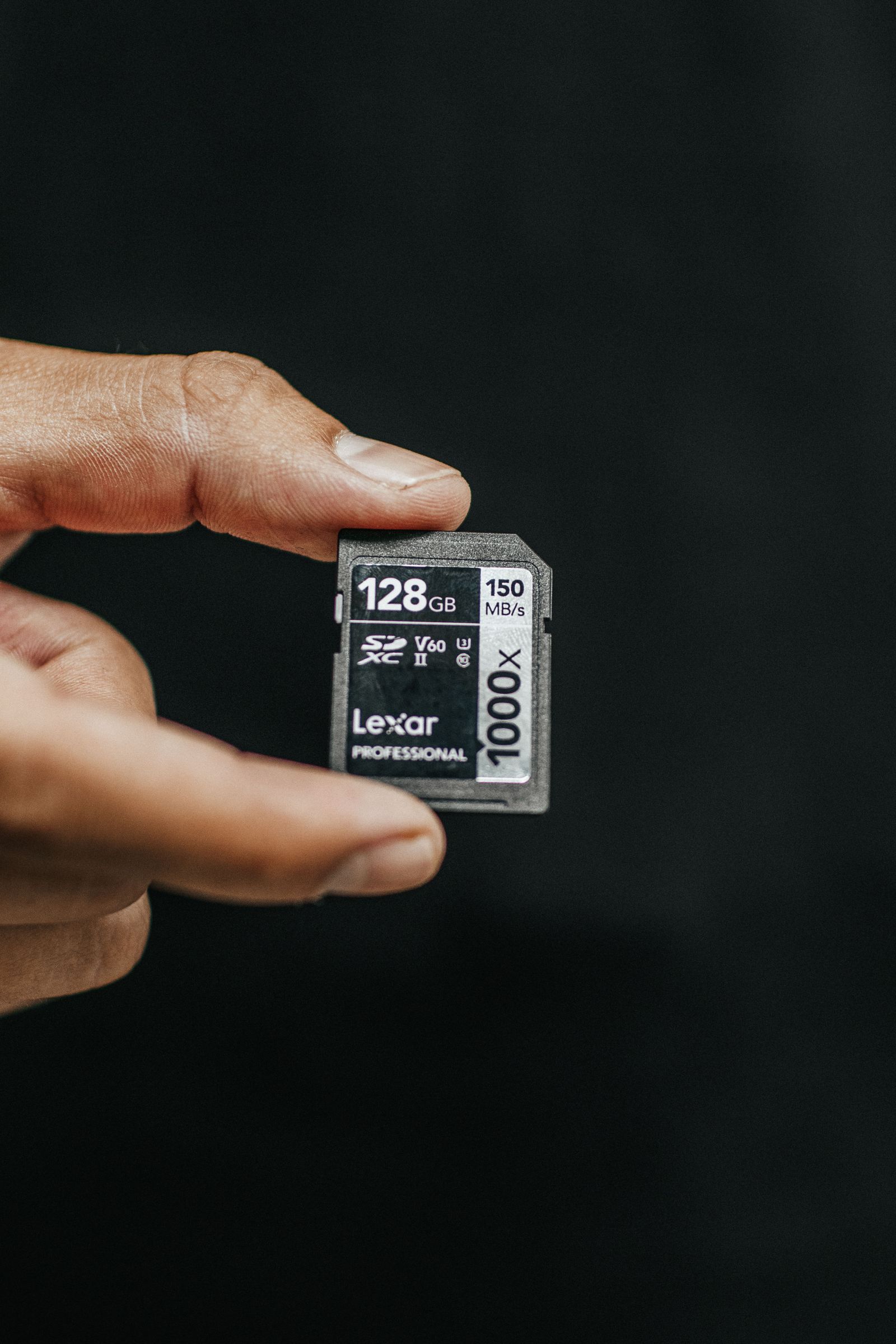 Close-up of a memory card held between fingers